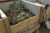 Compost organique dans une baie spécialement conçue, montrant des panneaux de retenue amovibles pour l'accès