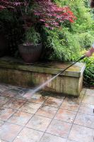 Lavage sous pression du jardin patio carrelé pour éliminer la mousse et les algues