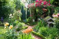 Jardin de campagne informel avec pavillon avec rosier grimpant