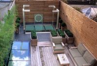 Jardin sur le toit contemporain avec terrasse en bois, sièges, éclairage et sphères Buxus en pots - Wilton Place, Londres