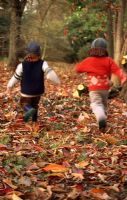 Enfants qui courent parmi les feuilles qui tombent