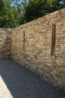 Murs en pierre sèche contemporains dans une cour murée pour le parking