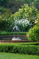 Piscine de nénuphars avec sculpture de hérons dans la roseraie - Mariners Garden, Berkshire