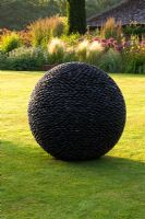 La sculpture du noyau sur une pelouse à l'aube - Pettifers Garden, Oxfordshire