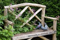 Banquette en bois avec statues de pigeon et Geranium palmatum - Eldenhurst