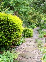 Chemin de gravier et balisé à travers un jardin de chalet