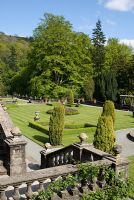 Balustrades, urnes, parterres géométriques à bords arrondis et ifs sculptés dans le jardin en terrasse à Rydal Hall, Cumbria