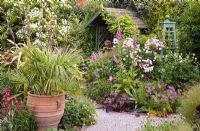 Vue de la tonnelle de jardin de parterres mixtes dans un jardin de banlieue assez isolé avec des caractéristiques de conception coordonnées et des parterres à thème de couleur - High Trees, NGS, Longton, Stoke-on-Trent, Staffordshire