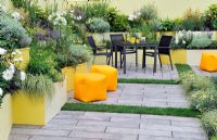 Jardin de patio avec une vaste plantation dans des parterres surélevés peints de couleurs vives - RHS Tatton Park Flower Show