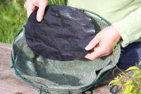 Planter un panier suspendu - ajouter un disque en plastique à la doublure en fibre