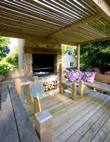Cuisine extérieure avec terrasse en bois, four et bancs - Jardin de Clare Matthew, Devon