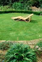 Siège sur pelouse circulaire avec Morina langifolia en premier plan