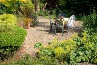 Table et chaises décoratives en métal dans le jardin de gravier d'été à 'Hazelwood', Jacqueline Iddon Hardy Plants, jardin NGS, Lancashire