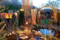 Jardin d'hiver avec étang éclairé au crépuscule