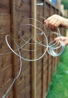 Utilisation des œillets à vis pour habiller une clôture - Fixez une extrémité du fil à un œillet à vis