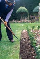 Tailler et ranger le bord de la pelouse - À l'aide du dos d'une houe, déplacez le sol du bord vers le parterre de fleurs. Maintenir un ravin entre les deux arrêts, les mauvaises herbes et l'enncroachment d'herbe