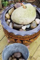 Fontaine de rocher dans un projet de pot. Étape 4. Insérez une double couche de maille galvanisée, positionnez le rocher et ajoutez des cailloux autour du bord.