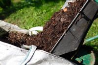 Faire du compost - Basculer les matériaux non pourris dans le sac du constructeur pour les convertir en compost