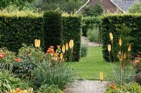 Hemerocallis 'Bold Tiger', Kniphofia 'Tawny King' et Rosa 'Sahara' dans un jardin et salon de thé néerlandais - De Tuinen à Demen