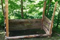 Construction d'un bac à compost - Clouez le bois en place à l'arrière et sur les côtés en utilisant un niveau pour garder le bac carré
