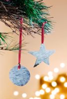 Faire des décorations de Noël à partir d'écorce de bouleau argenté - 11. Décorations finies, une étoile et une boule accrochée dans un arbre