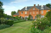 Jardin de campagne avec pelouses et parterres de Rosa - Roses et Lavandula - Lavande. Jardin Robinson, Ousden House, Suffolk