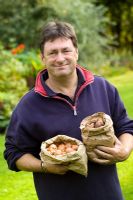 Alan Titchmarsh avec des paquets de bulbes prêts à planter