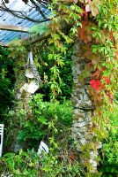 Abri à thé avec des colonnes construites en feldspath blanc, soutenant la vigne vierge et la fleur de la passion - Pinsla Garden, Cardinham, Cornwall