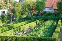 Jardin potager avec haies de Buxus sempervirens taillées, Rosa 'Leonardo da Vinci' et épouvantails