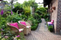 Petit jardin de ville avec des chaises en osier entouré de Digitalis - Foxgloves et Hortensia - Scheper Town Garden