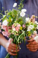 Femme tenant un bouquet de Consolida - Larkspur 'Pale Pink', Buplerum grifithii, Centaurea - Bleuet, Achillea 'The Pearl' - Growing Together Nursery