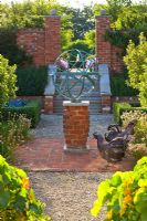 Cadran solaire armillaire en métal et statues de poule sur patio en brique rouge, Oxfordshire