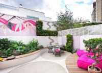 Petit jardin patio avec terrasse en bois, chaises roses, mosaïque par Celia Gregory, Londres.