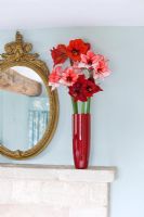 Cheminée avec vase rempli de fleurs coupées d'Amaryllis - Hippeastrum 'Charisma', 'Ferrari' et 'Benfica '