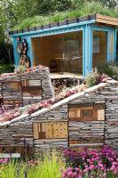Studio de jardin avec toit vert et hôtels à insectes construits pour sécher les murs en pierre