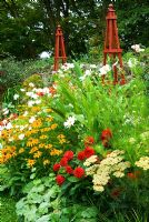 Parterre de fleurs décoratif ponctué d'obélisques en bois rouges