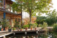 Vue sur maison contemporaine avec terrasse en bois et piscine naturelle, Garden Hackl, Mistelbach Autriche