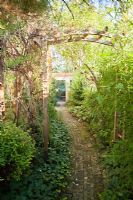 Chemin pavé sous une arche en bois vers l'entrée du jardin, Garden Hackl, Mistelbach Autriche
