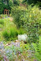 Jardin en pierre au sud de la maison comprend Salvia forsskaolii, grand Helianthus microcephalus jaune et Artemisia alba 'Canescens' - Holbrook Garden, Tiverton, Devon, UK