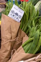 Des paquets de haricots verts sur l'étal du marché