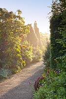 Tôt le matin, la brume et la lumière du soleil sur les parterres de fleurs à RHS Garden Rosemoor, Great Torrington, Devon