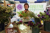 Rachel vendant des fleurs sur l'étal du marché au marché des fermiers - Vert et magnifique