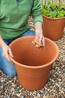 Étape par étape Planter un pot à thème orange et bleu - placer des pots cassés au fond du pot