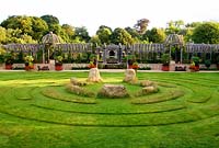 Une pergola à double dôme en chêne enjambe le jardin séparant les cours supérieures en gravier de la pelouse inférieure avec le labyrinthe et les pierres centrales. The Collector Earl's Garden conçu par Julian et Isabel Bannerman.