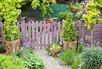 Piquet de clôture et portail traité avec du bois de lavande, des arbres et des arbustes matures au feuillage vibrant - High Meadow Garden à la fin du printemps, Staffordshire
