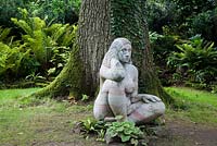 La sculpture d'une nymphe des bois (déesse des bois) se trouve dans la posture méditative, dans le Stumpery. Highgrove Garden, août 2007.