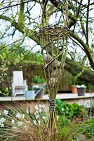 Mangeoire à oiseaux saule fait à la main dans le jardin de printemps avec terrasse en bois