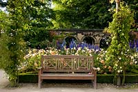 Banc en bois devant le parterre de fleurs, le jardin d'ornement. Jardin d'Alnwick. Royaume-Uni