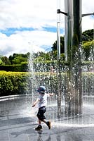 Enfant jouant dans le jardin du serpent. Jardin d'Alnwick. Royaume-Uni