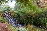 L'une des chutes d'eau parmi les jardins paysagers en automne. Jardins de Minterne, Minterne Magna, Dorset